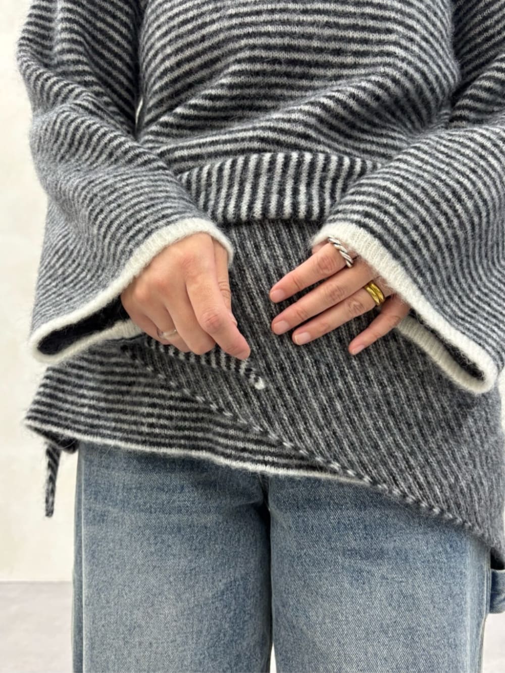 ブルー系のデニムパンツ、ブラック系のブーツ、ブラック系のニット/セーターを着用したレディースの秋コーディネートの2枚目の写真