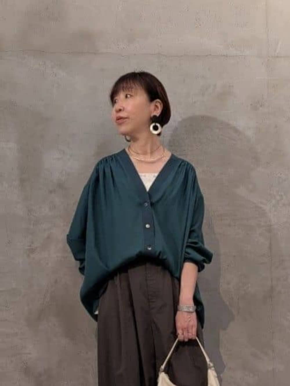 ホワイト系のトートバッグ、グレー系のその他パンツ、グリーン系のシャツ/ブラウスを着用したレディースの春コーディネートの4枚目の写真