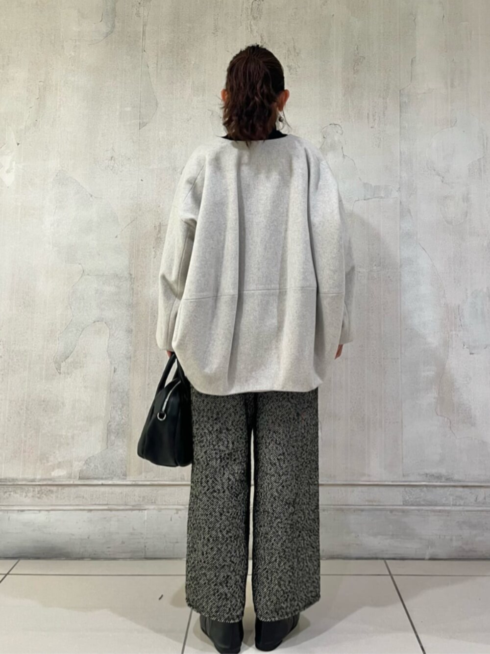 グレー系のノーカラーコート、ブラック系のその他パンツを着用したレディースの秋コーディネートの2枚目の写真