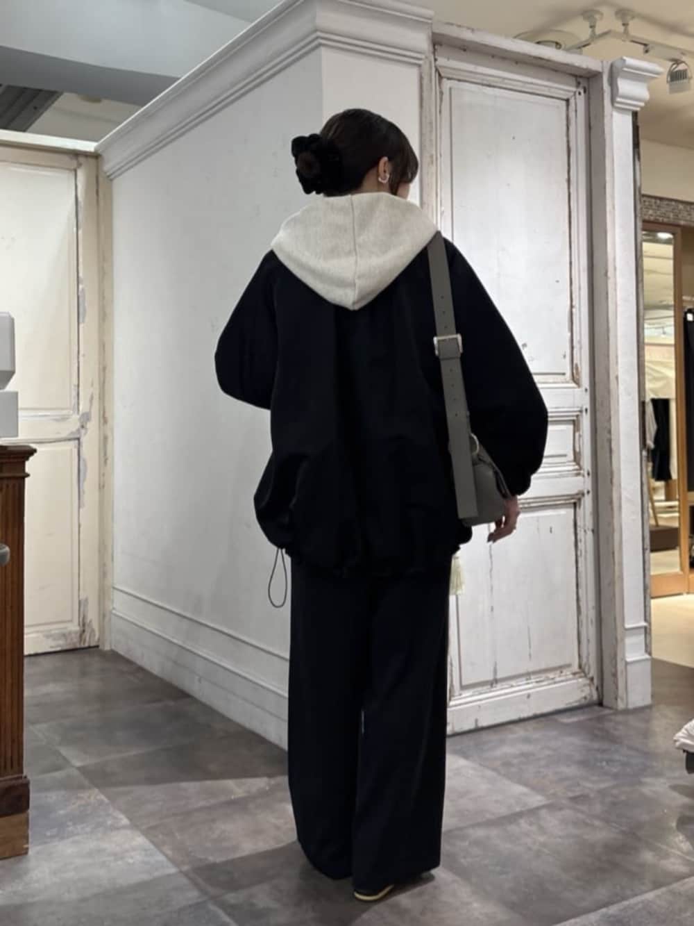 ブラック系のその他パンツ、ホワイト系のパーカー、グレー系のショルダーバッグを着用したレディースの冬コーディネートの3枚目の写真