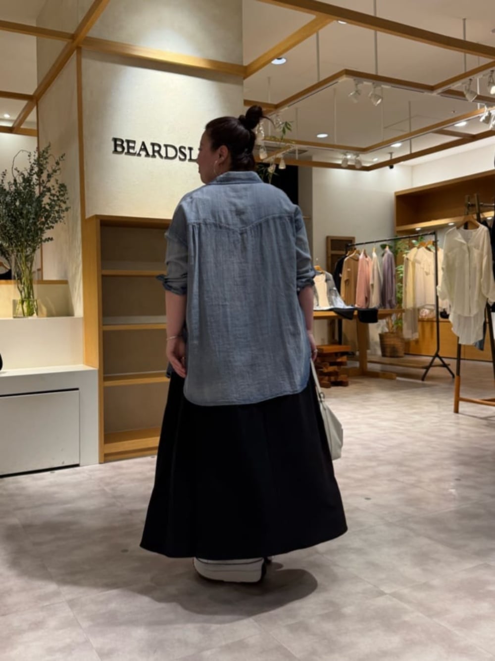 ブルー系のシャツ/ブラウス、ブラック系のショルダーバッグ、ブラック系のワンピースを着用したレディースの春コーディネートの4枚目の写真