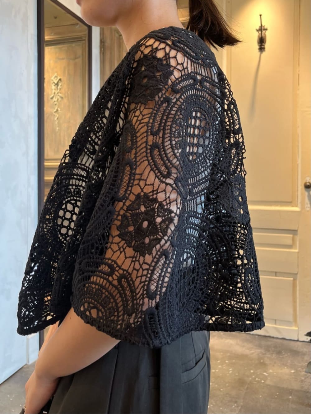 ホワイト系のタンクトップ、ブラック系のポンチョ、グレー系のその他パンツを着用したレディースの冬コーディネートの7枚目の写真