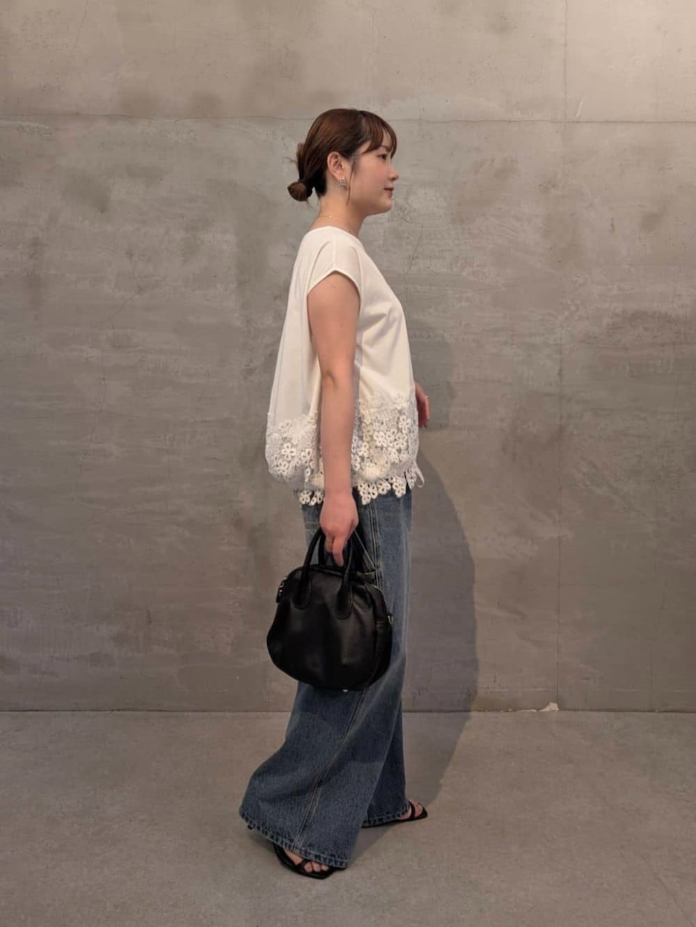 ブラック系のボストンバッグ、ブルー系のその他パンツ、ホワイト系のTシャツ/カットソーを着用したレディースの春コーディネートの3枚目の写真