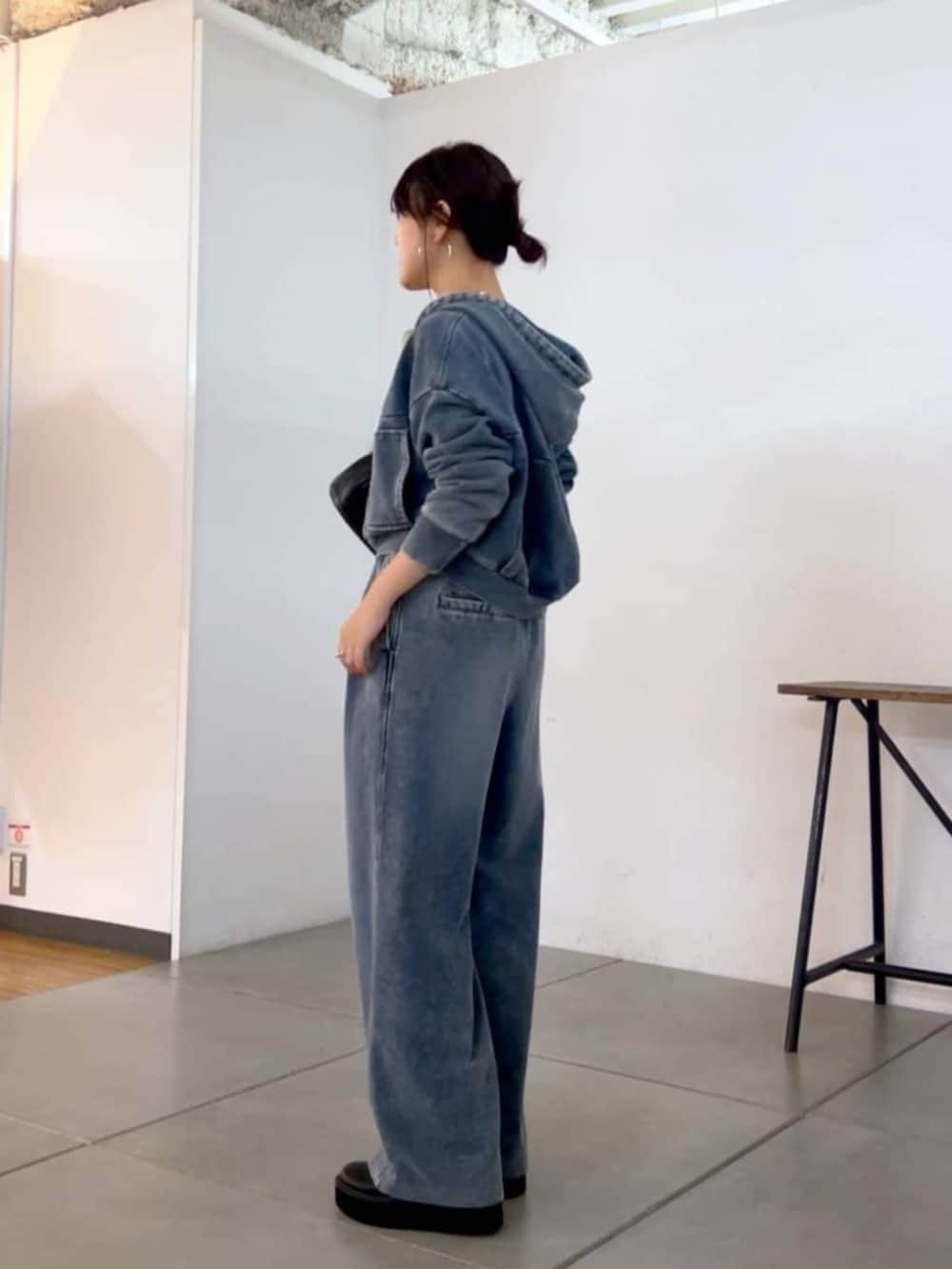 ブラック系のショルダーバッグ、ブルー系のその他パンツ、ブルー系のパーカーを着用したレディースの秋コーディネートの6枚目の写真