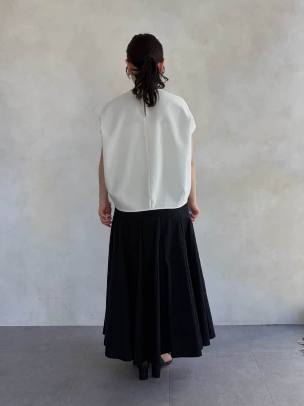 ブラック系のハンドバッグ、ホワイト系のシャツ/ブラウス、ブラック系のスカートを着用したレディースの春コーディネートの3枚目の写真