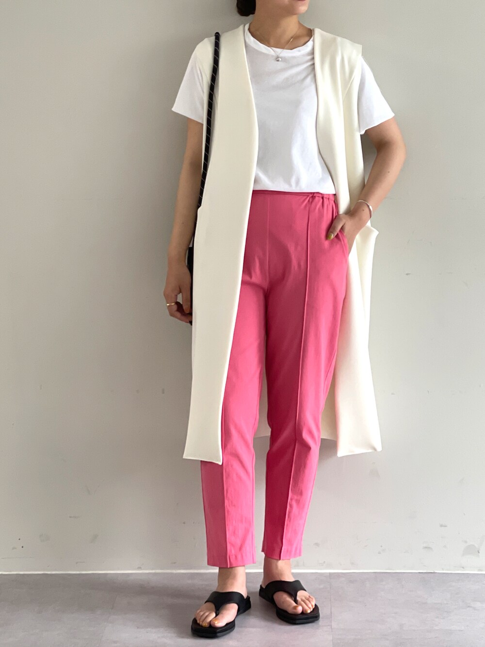 ホワイト系のベスト、ピンク系のその他パンツを着用したレディースの夏コーディネートの2枚目の写真