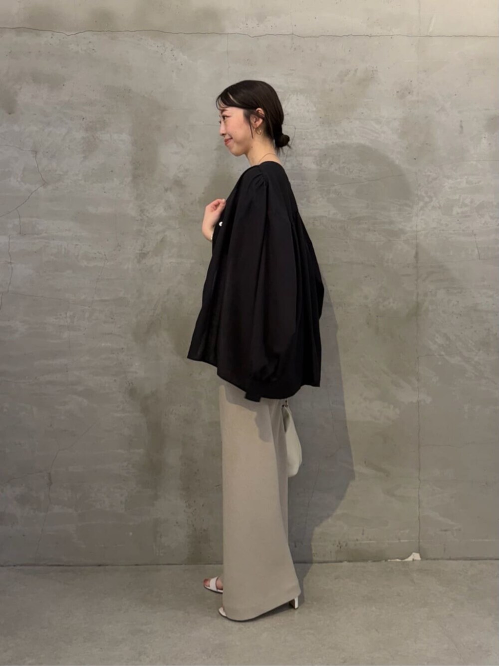ホワイト系のトートバッグ、ブラック系のシャツ/ブラウス、ベージュ系のその他パンツを着用したレディースの冬コーディネートの2枚目の写真