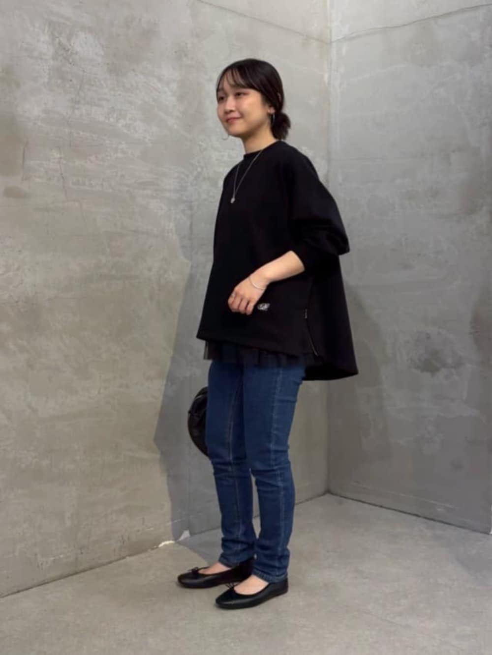 ブラック系のTシャツ/カットソー、ブラック系のキャミソール、ブルー系のデニムパンツを着用したレディースの夏コーディネートの2枚目の写真