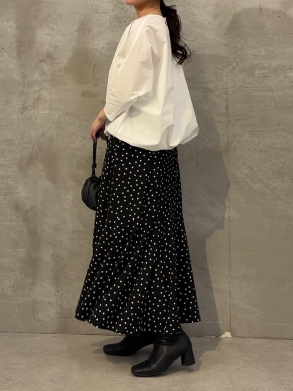 ホワイト系のシャツ/ブラウス、ブラック系のスカート、シルバー系のネックレスを着用したレディースの冬コーディネートの3枚目の写真