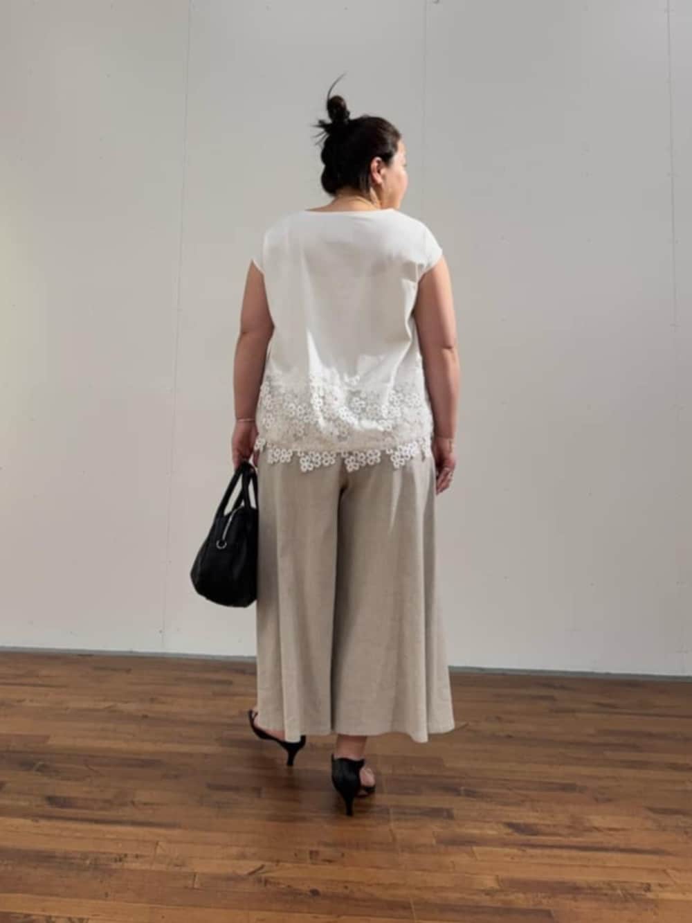 ブラック系のボストンバッグ、ホワイト系のTシャツ/カットソー、ベージュ系のその他パンツを着用したレディースの春コーディネートの5枚目の写真