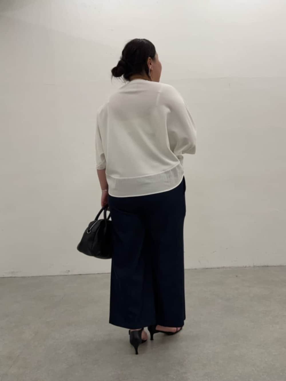 ブラック系のボストンバッグ、ブルー系のその他パンツ、ホワイト系のTシャツ/カットソーを着用したレディースの春コーディネートの5枚目の写真