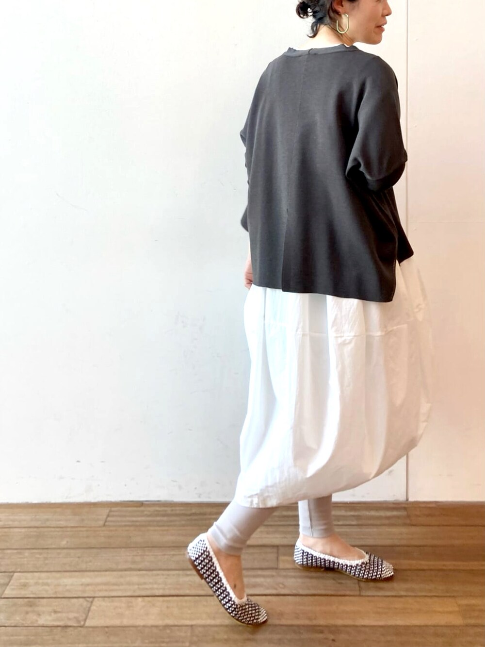 ホワイト系のワンピース、ブラック系のカーディガン/ボレロ、グレー系のその他パンツを着用したレディースの春コーディネートの3枚目の写真