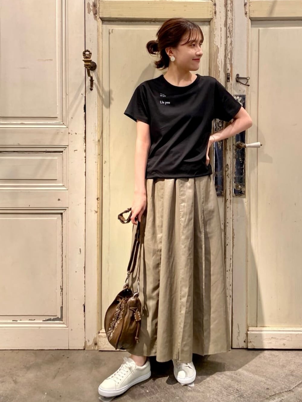 グリーン系のスカート、グリーン系のショルダーバッグを着用したレディースの秋コーディネートの4枚目の写真