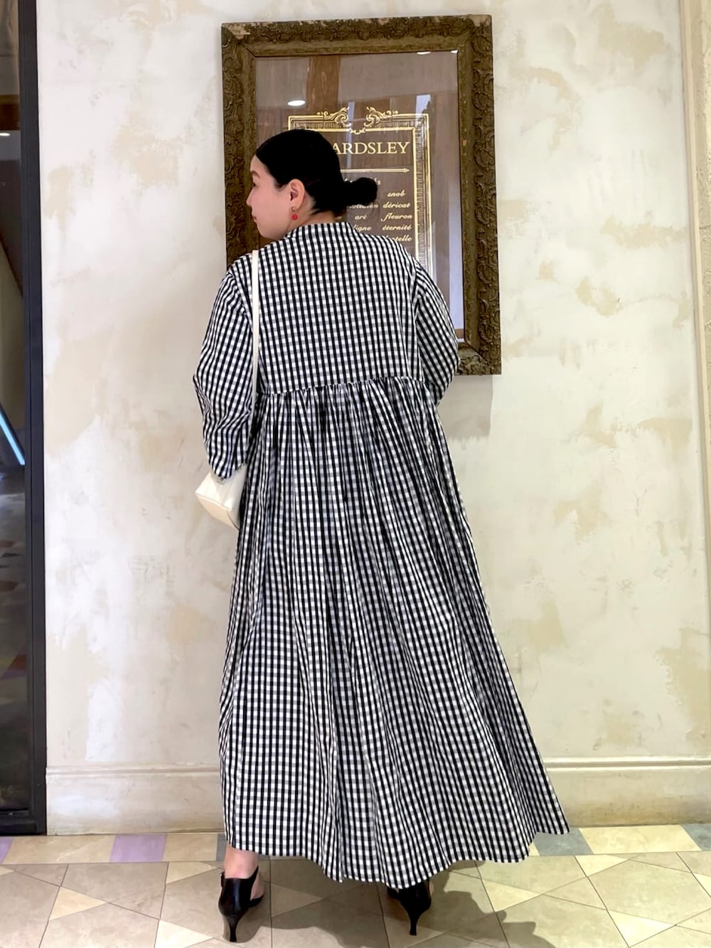 ブラック系のワンピース、ホワイト系のショルダーバッグを着用したレディースの夏コーディネートの3枚目の写真