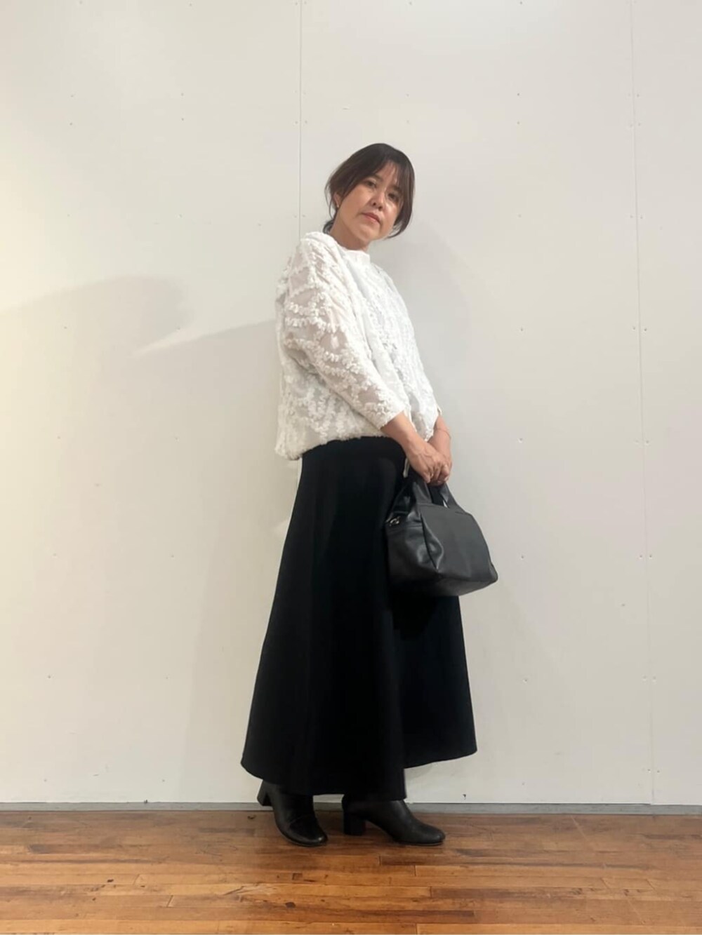 ブラック系のボストンバッグ、ブラック系のスカート、ホワイト系のシャツ/ブラウスを着用したレディースの夏コーディネートの4枚目の写真