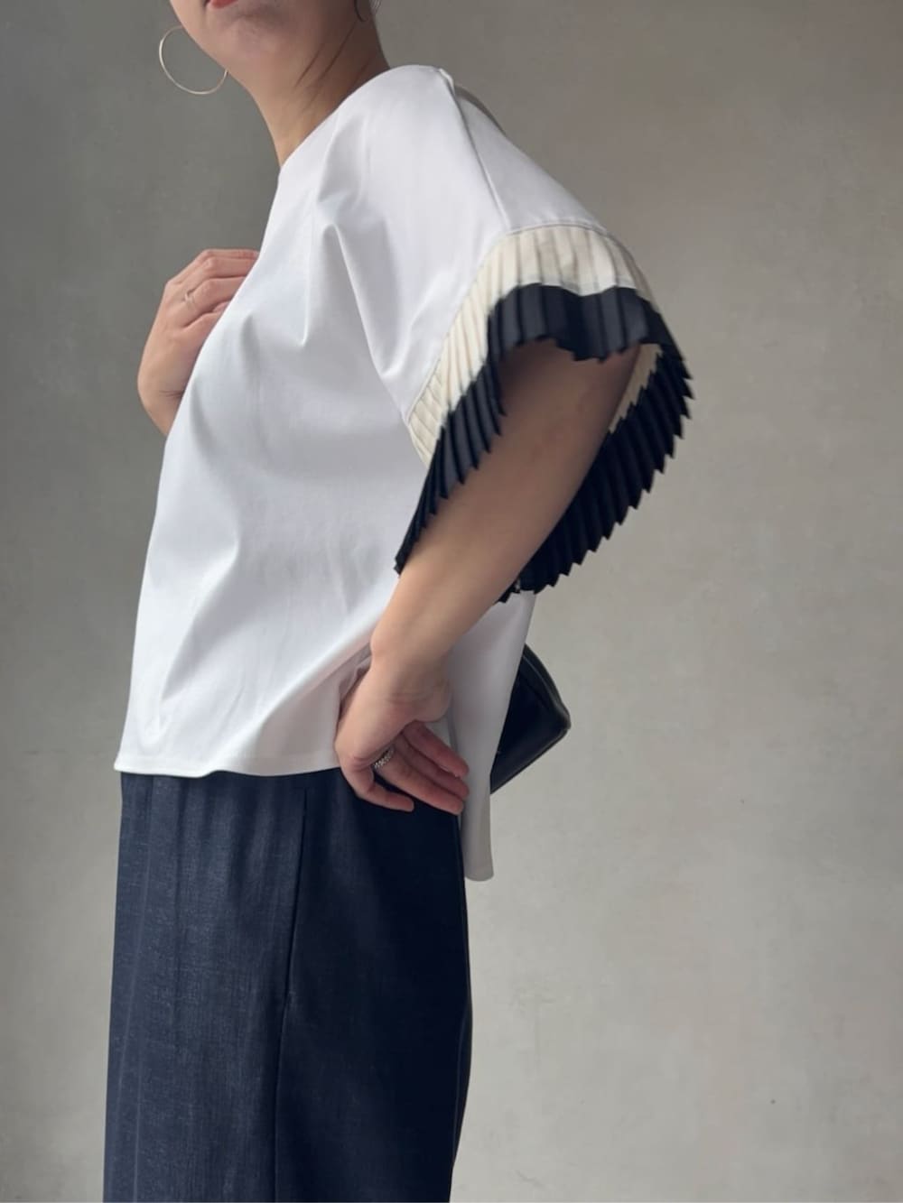 ブルー系のその他パンツ、ブラック系のショルダーバッグ、ホワイト系のサンダルを着用したレディースの春コーディネートの7枚目の写真