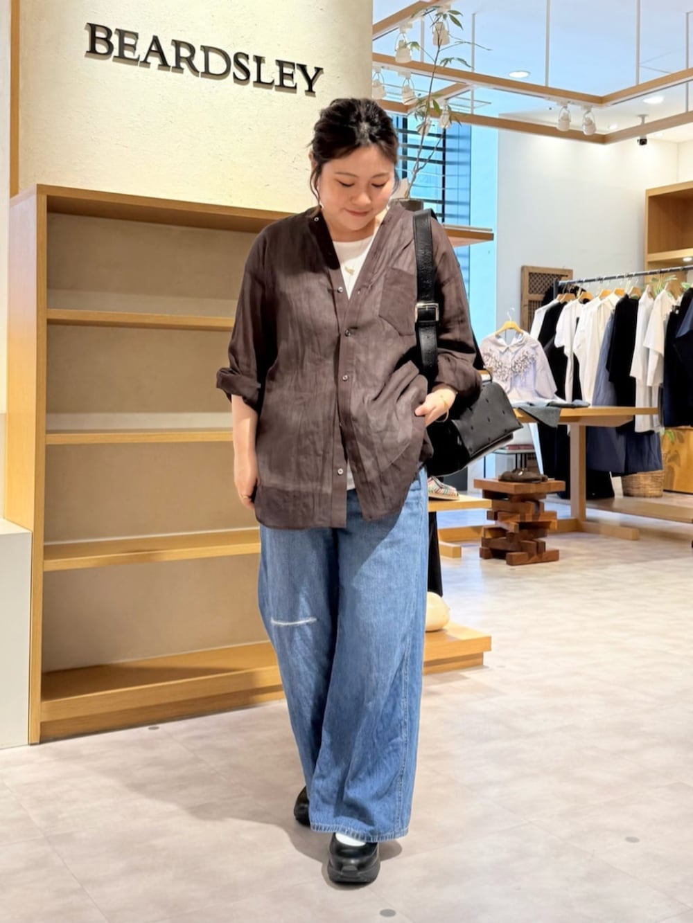 ブルー系のその他パンツ、ブラック系のスニーカー、ブラウン系のシャツ/ブラウスを着用したレディースの春コーディネートの3枚目の写真