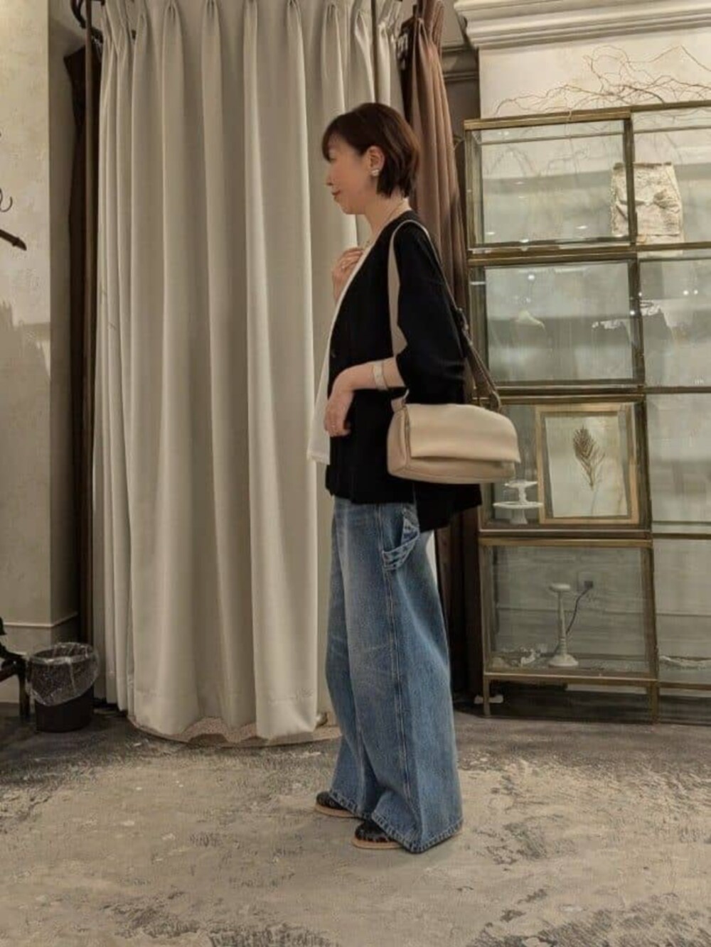 ホワイト系のタンクトップ、ベージュ系のショルダーバッグ、ブルー系のその他パンツを着用したレディースの春コーディネートの2枚目の写真