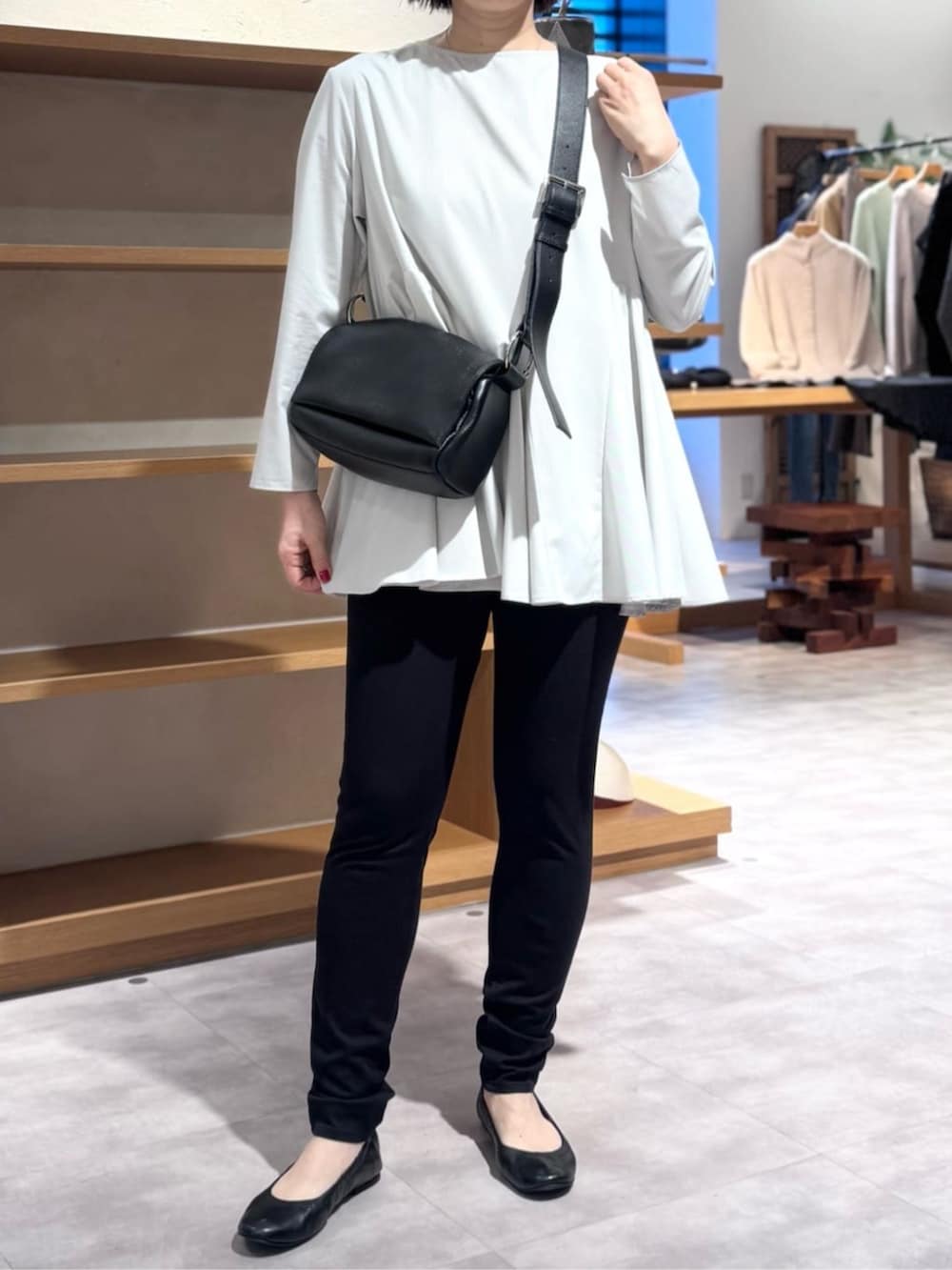 ブラック系のその他パンツ、ブラック系のショルダーバッグ、ホワイト系のTシャツ/カットソーを着用したレディースの冬コーディネートの2枚目の写真