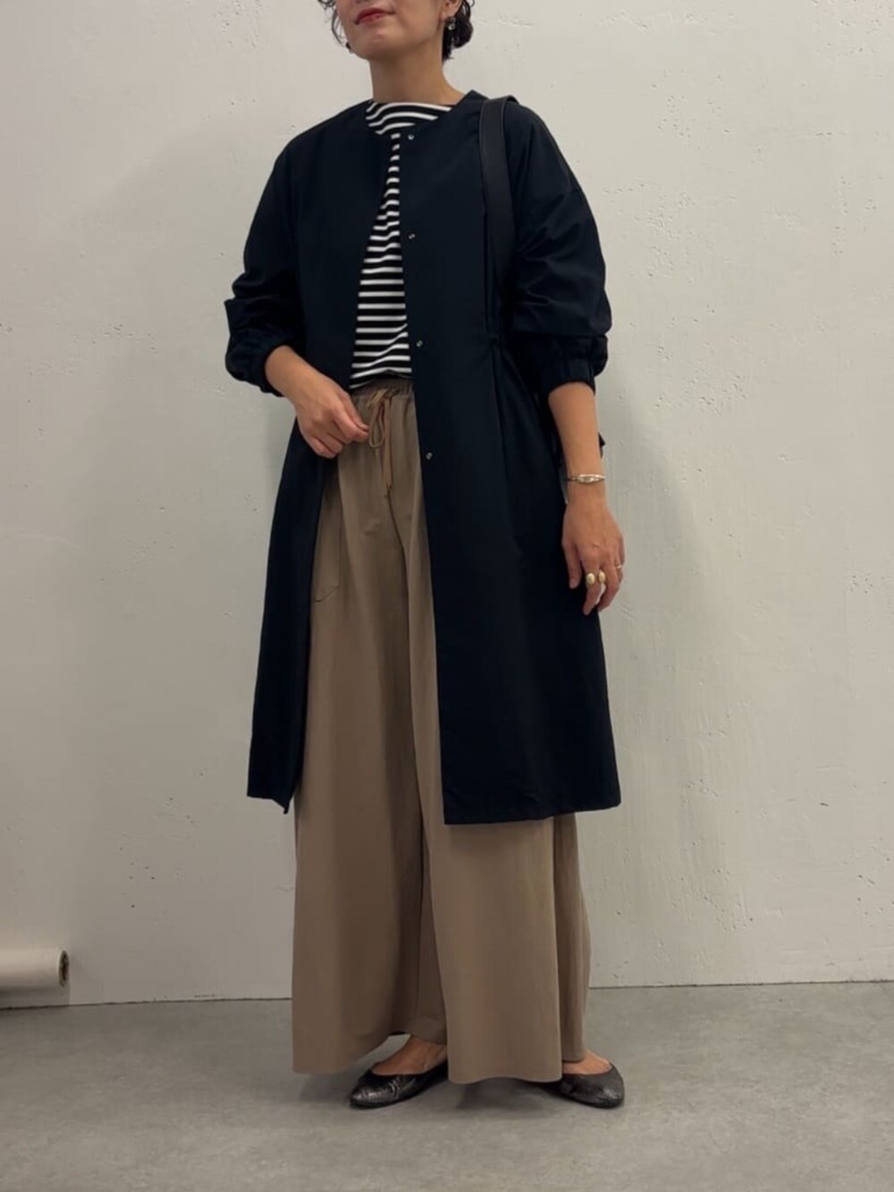 ブルー系のその他アウター、ベージュ系のその他パンツ、ブラック系のTシャツ/カットソーを着用したレディースの冬コーディネートの2枚目の写真
