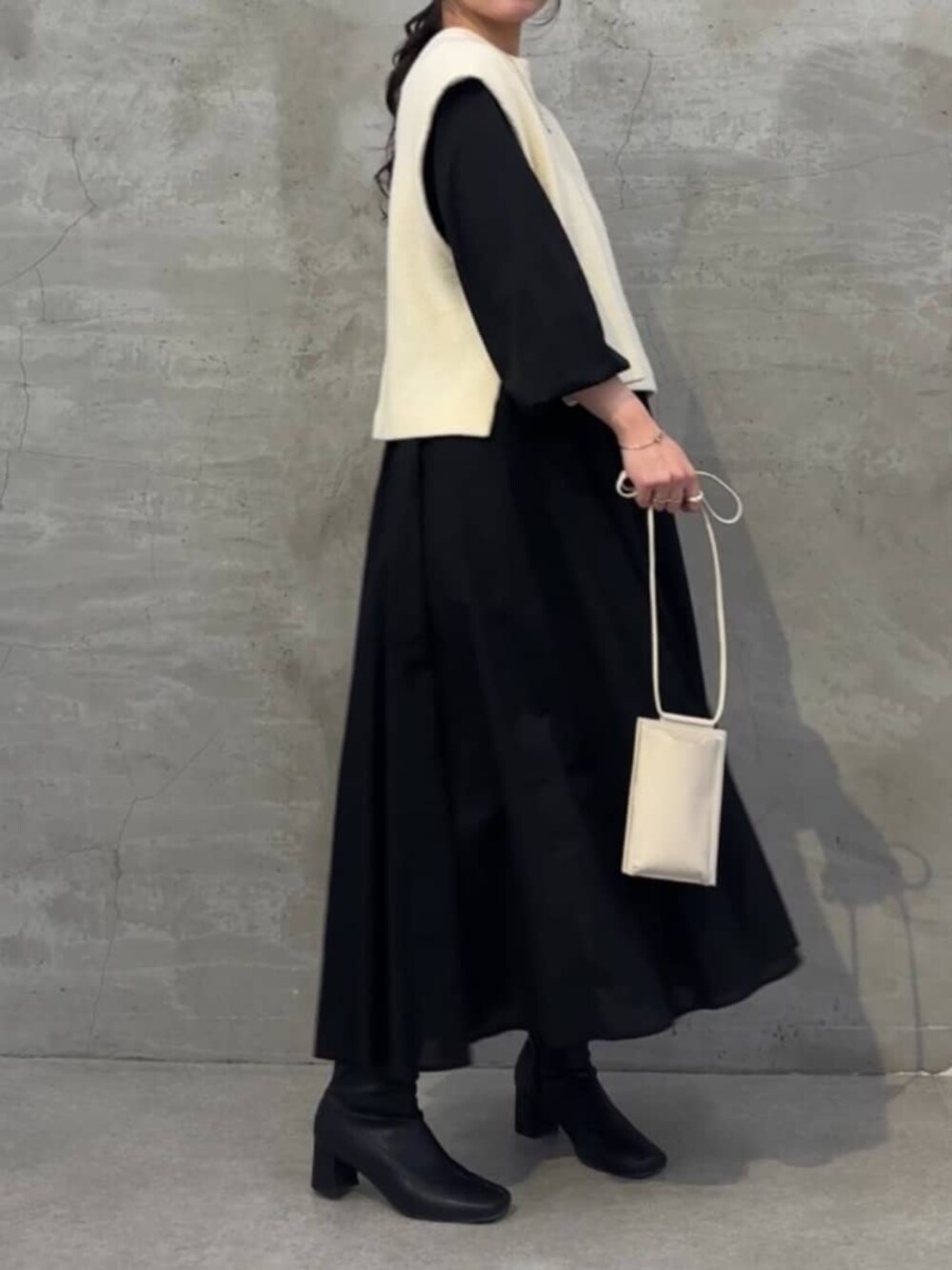 ブラック系のワンピース、ホワイト系のシャツ/ブラウス、ホワイト系のショルダーバッグを着用したレディースの冬コーディネートの7枚目の写真