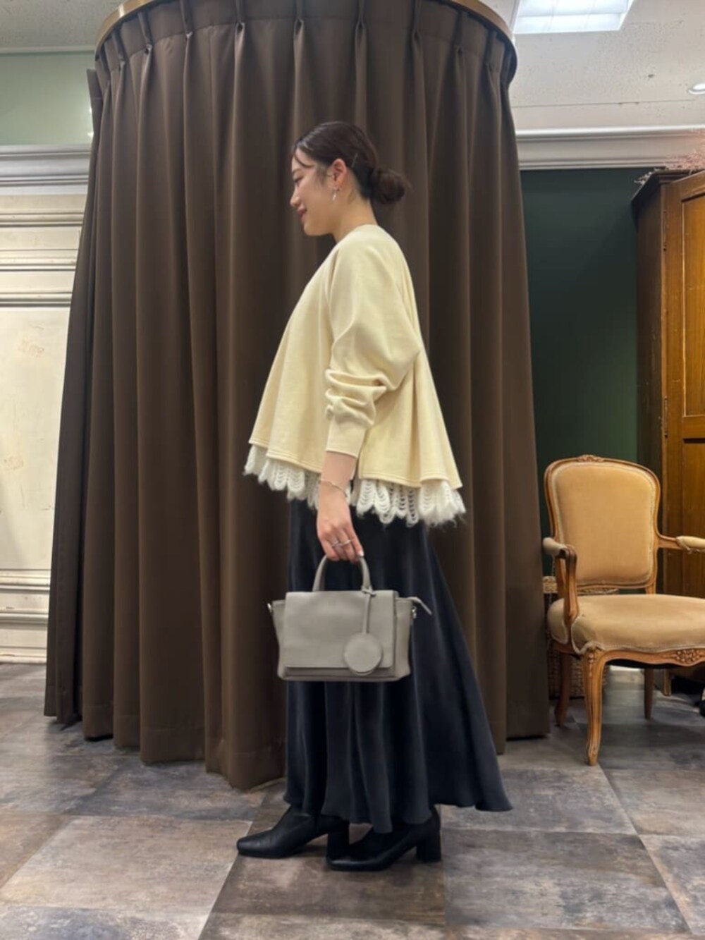 ブラック系のスカート、グレー系のハンドバッグ、ホワイト系のTシャツ/カットソーを着用したレディースの冬コーディネートの2枚目の写真