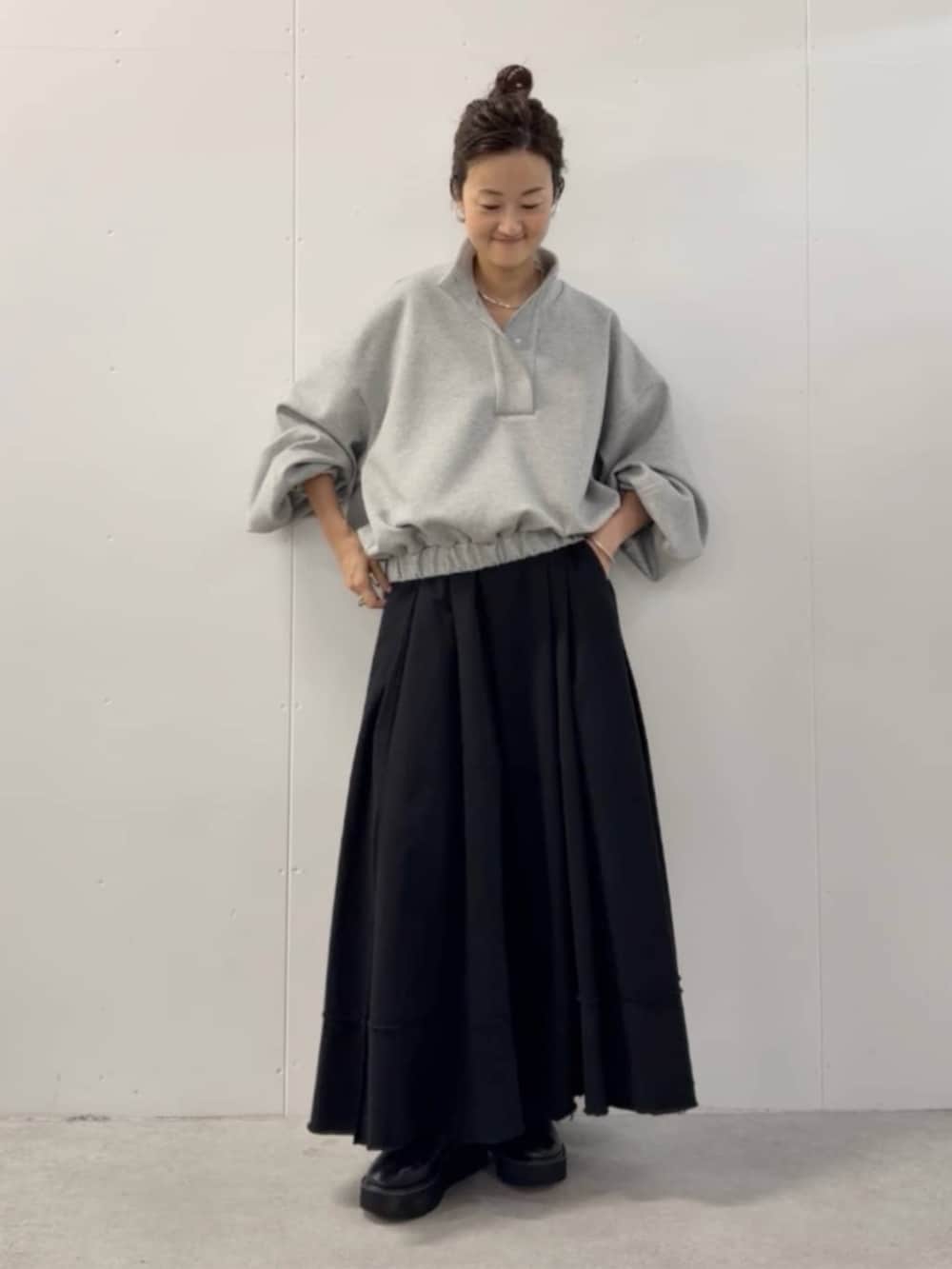 ブラック系のショルダーバッグ、ブラック系のスカート、グレー系のTシャツ/カットソーを着用したレディースの夏コーディネートの10枚目の写真