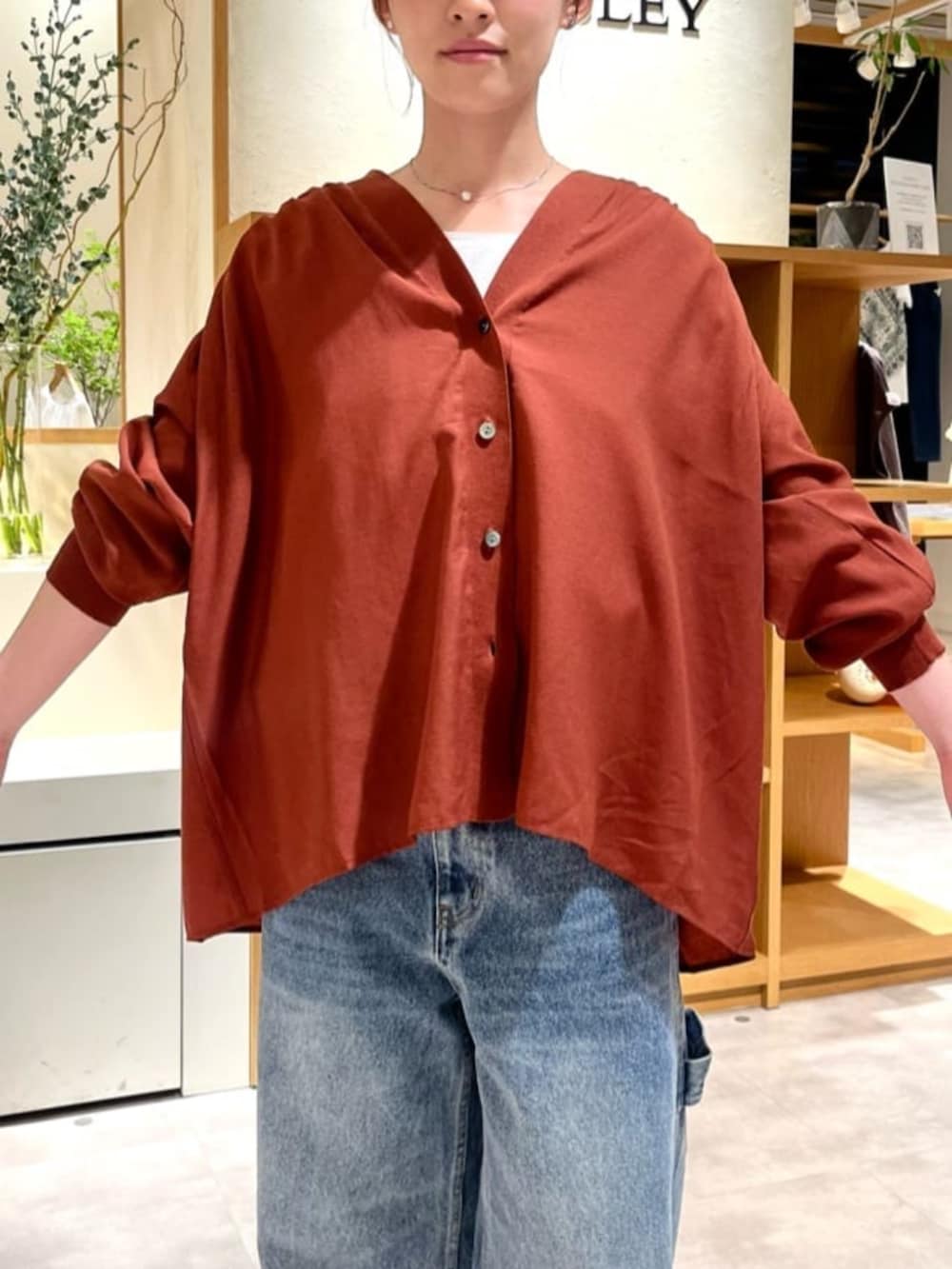レッド系のシャツ/ブラウス、ブルー系のデニムパンツを着用したレディースの夏コーディネートの8枚目の写真