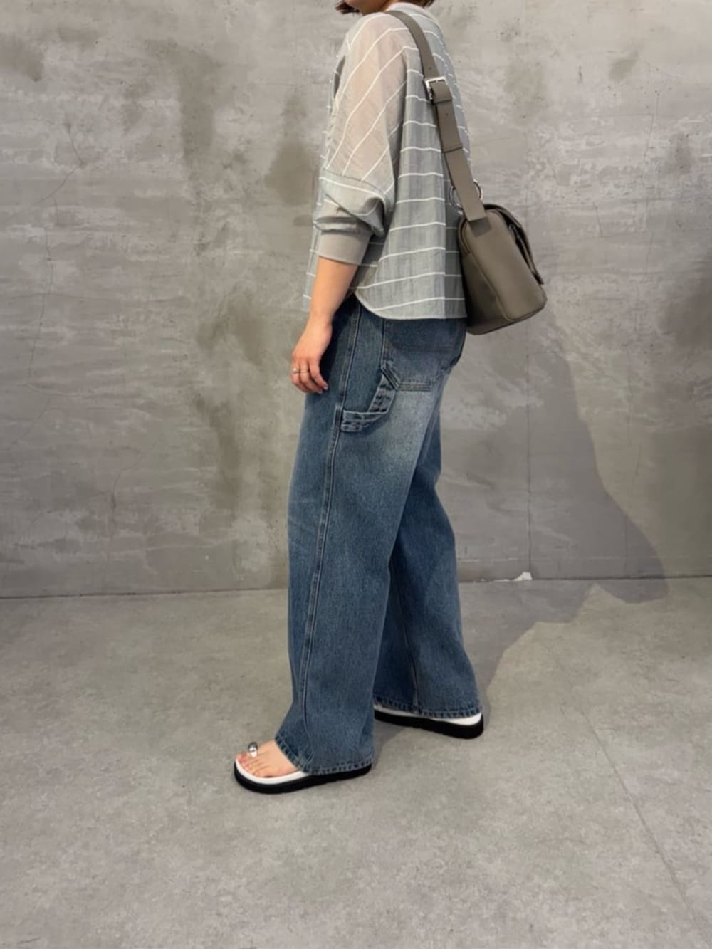 ブルー系のその他パンツ、ホワイト系のサンダル、グレー系のシャツ/ブラウスを着用したレディースの春コーディネートの3枚目の写真