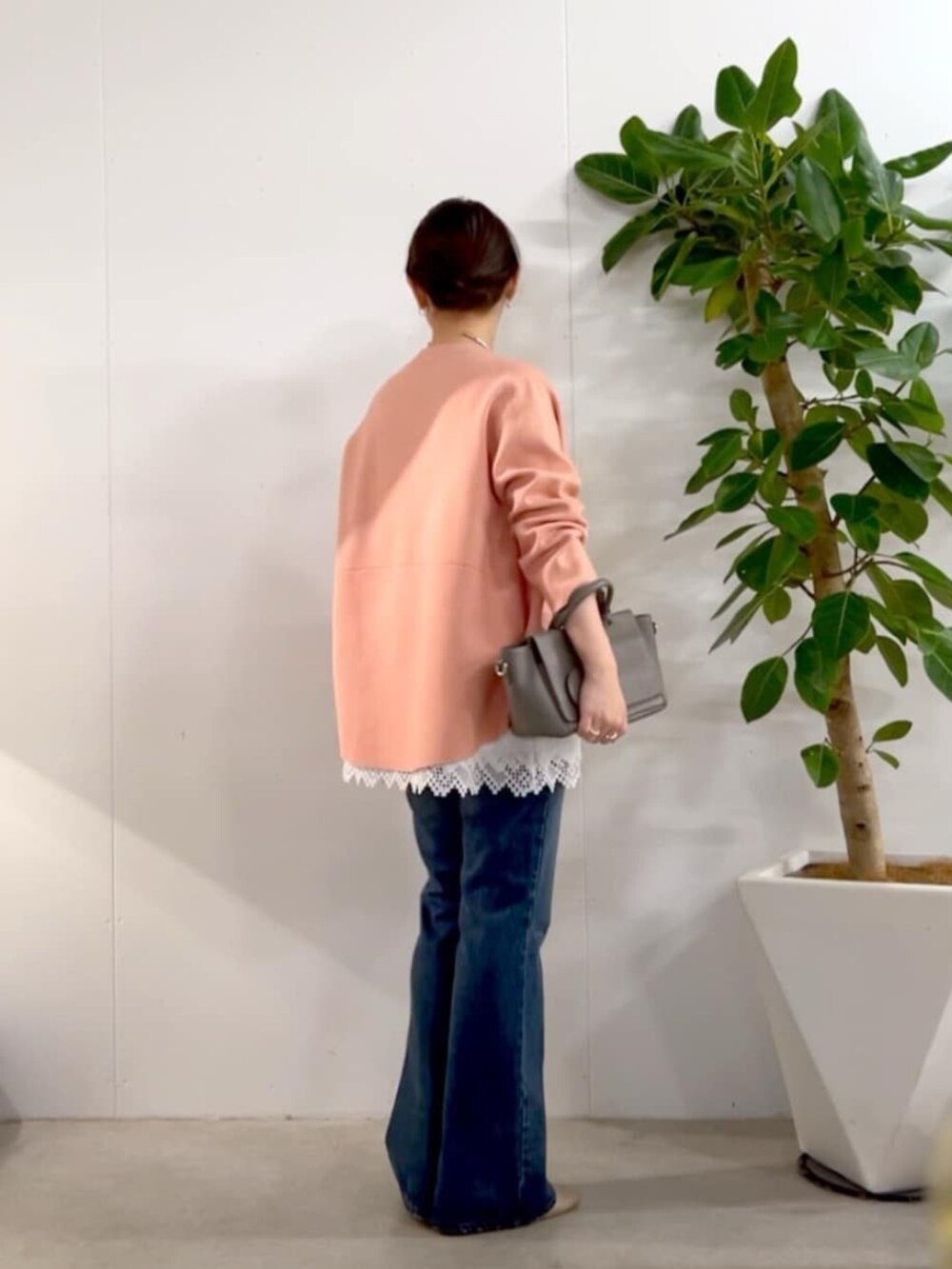グレー系のハンドバッグ、ピンク系のニット/セーター、ホワイト系のキャミソールを着用したレディースの秋コーディネートの8枚目の写真