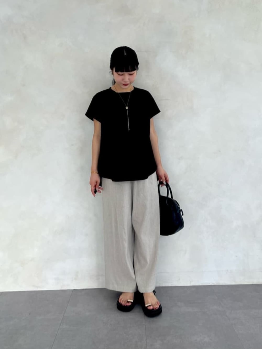 ベージュ系のその他パンツ、ブラック系のTシャツ/カットソー、ブラック系のサンダルを着用したレディースの春コーディネートの3枚目の写真