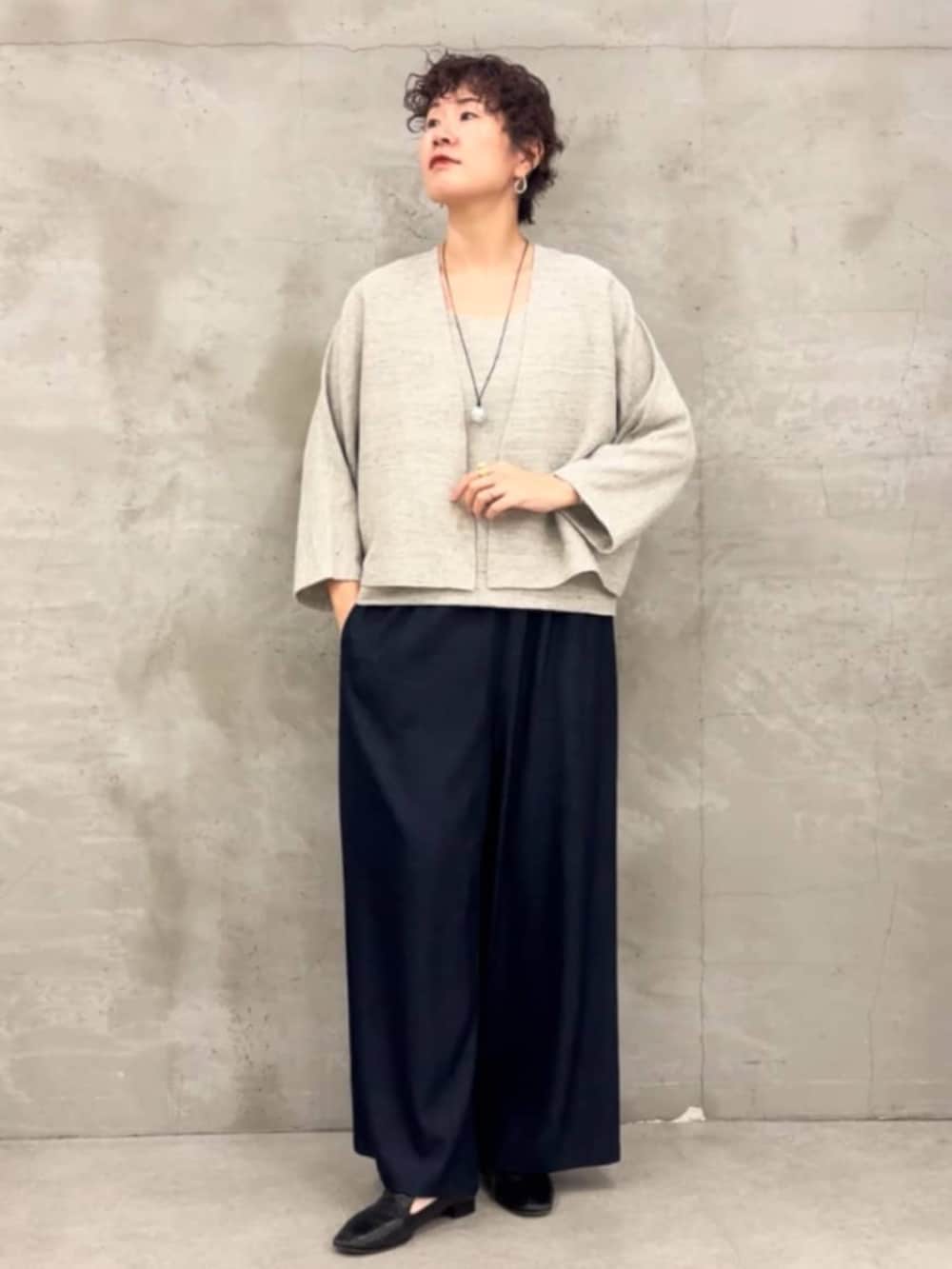 ブルー系のその他パンツ、グレー系のニット/セーター、グレー系のカーディガン/ボレロを着用したレディースの春コーディネートの4枚目の写真