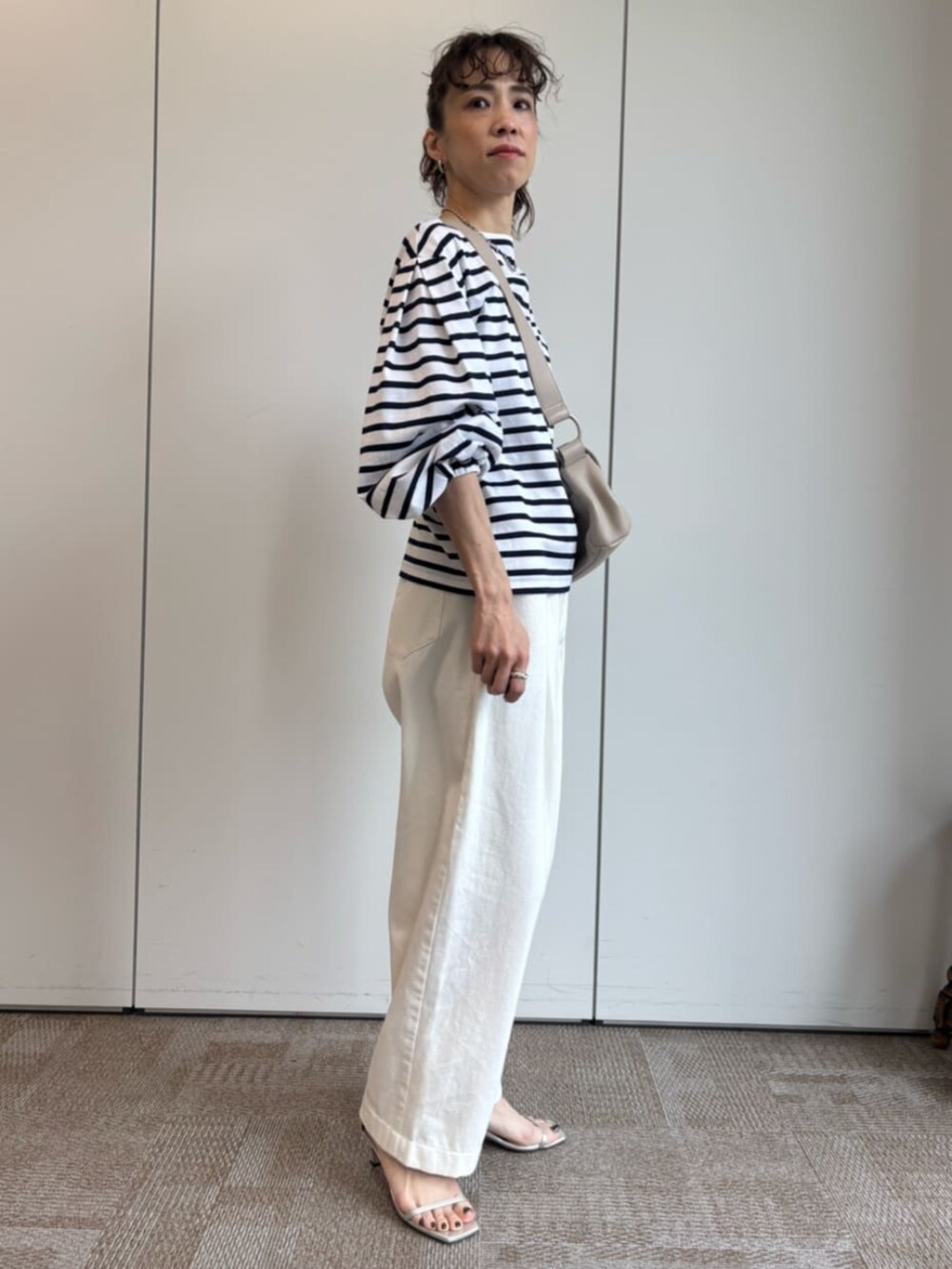 ベージュ系のショルダーバッグ、ホワイト系のTシャツ/カットソーを着用したレディースの冬コーディネートの3枚目の写真