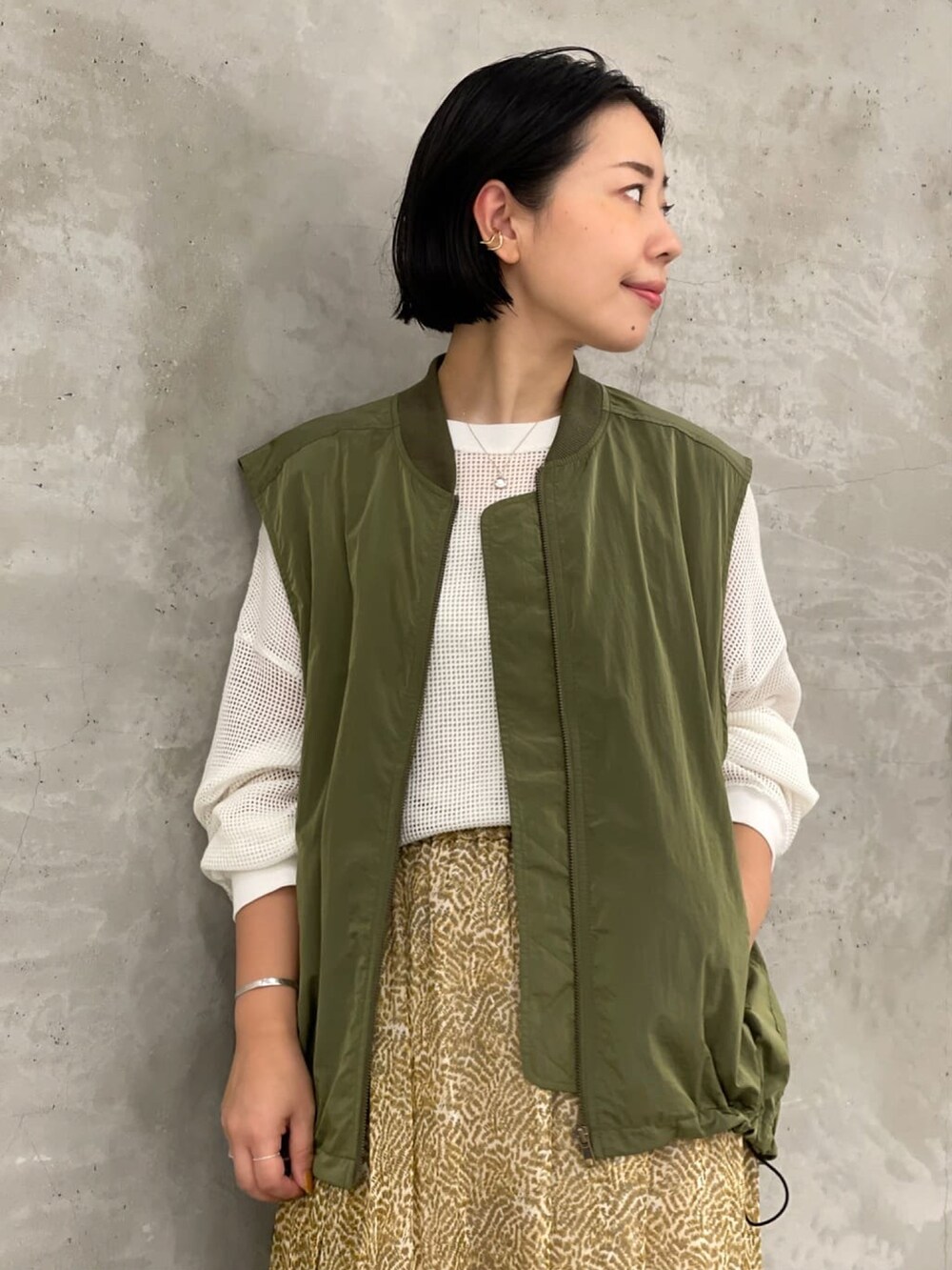 ホワイト系のTシャツ/カットソー、グリーン系のベスト、ベージュ系のスカートを着用したレディースの夏コーディネートの5枚目の写真