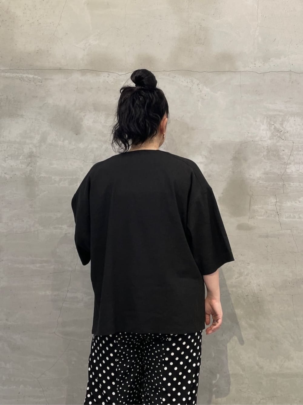 ホワイト系のタンクトップ、ブラック系のボストンバッグ、ブラック系のサンダルを着用したレディースの春コーディネートの5枚目の写真