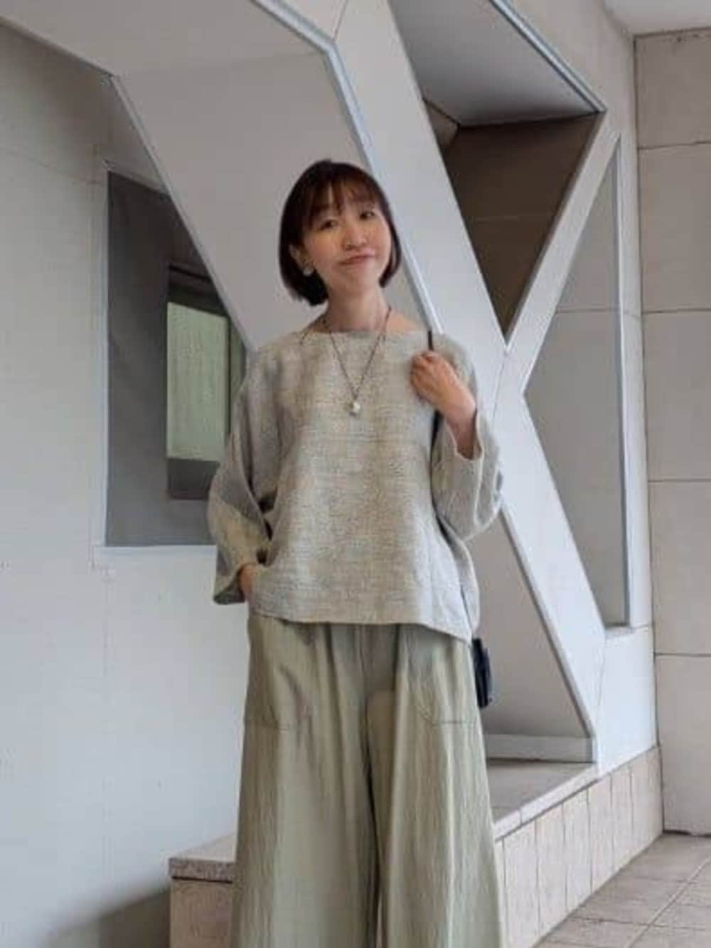 グリーン系のその他パンツ、グレー系のニット/セーター、ブラック系のサンダルを着用したレディースの冬コーディネートの4枚目の写真