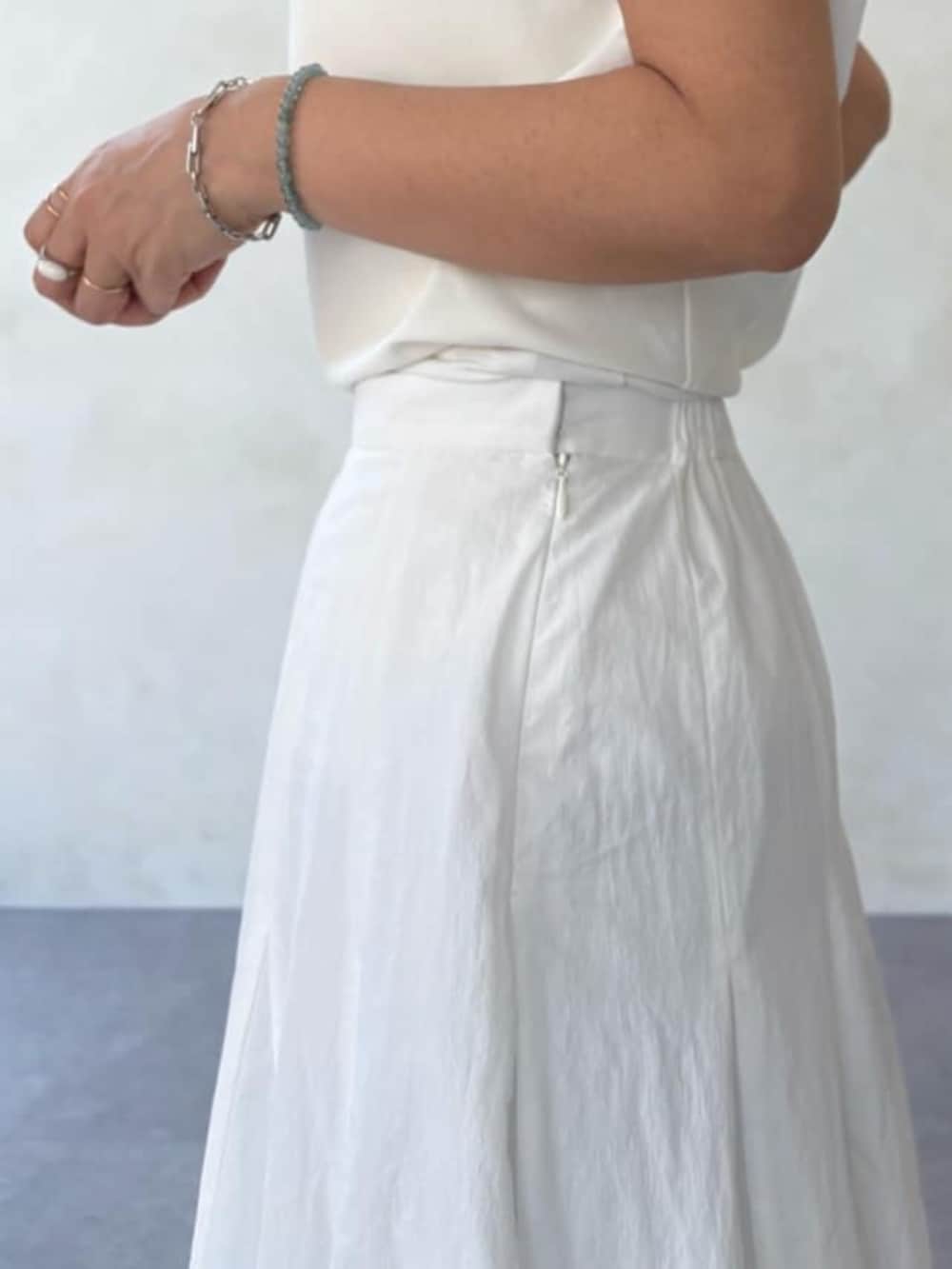 グレー系のハンドバッグ、ホワイト系のスカート、ホワイト系のシャツ/ブラウスを着用したレディースの春コーディネートの7枚目の写真