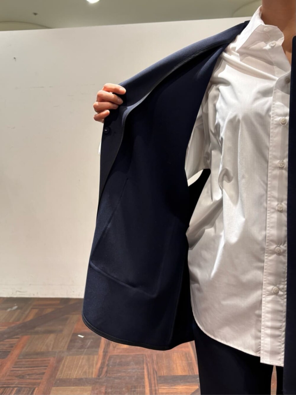 ブラック系のボストンバッグ、ブルー系のベスト、ホワイト系のシャツ/ブラウスを着用したレディースの冬コーディネートの7枚目の写真