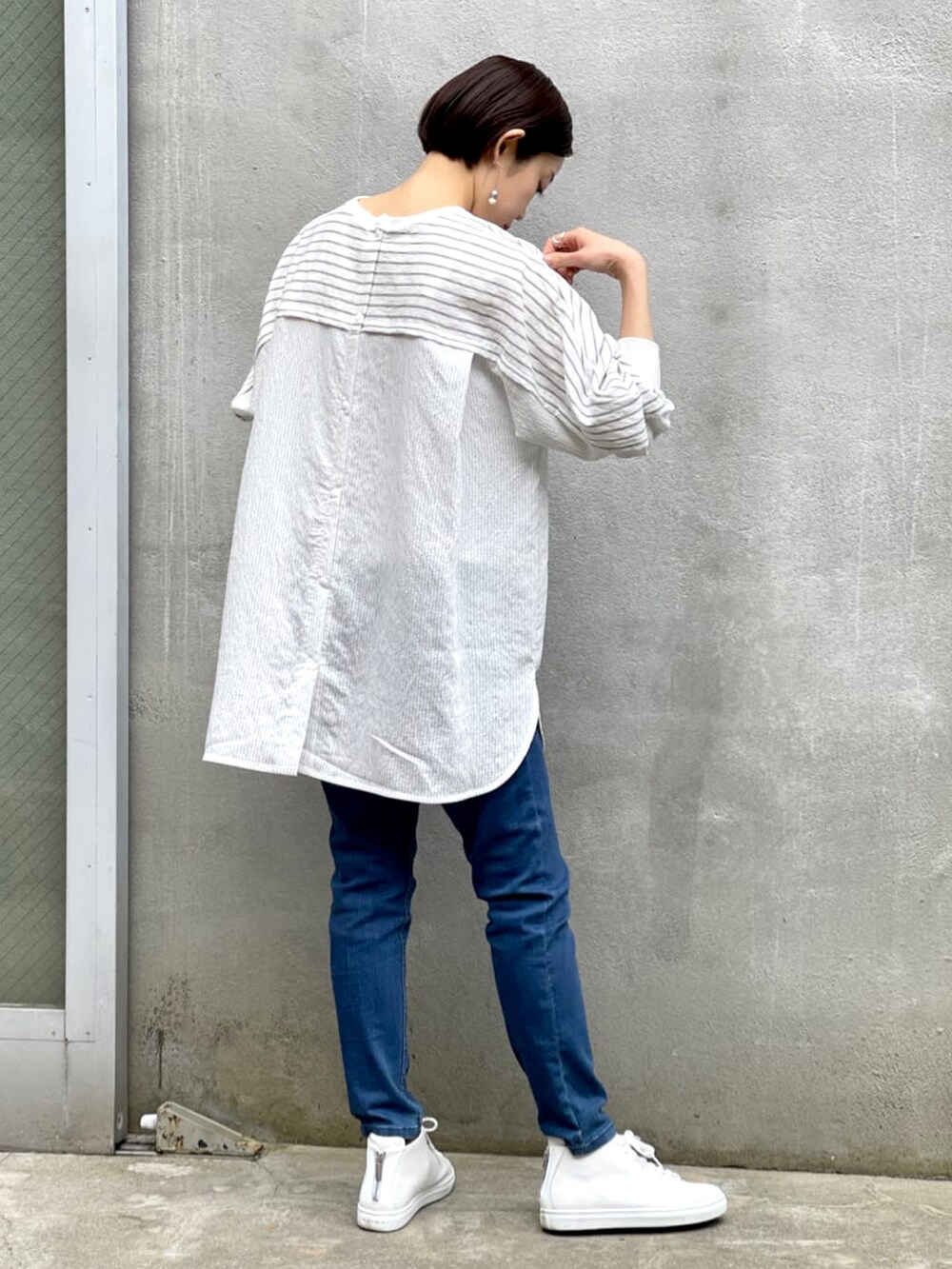 ブラック系のシャツ/ブラウス、ブルー系のデニムパンツ、ホワイト系のスニーカーを着用したレディースの春コーディネートの3枚目の写真