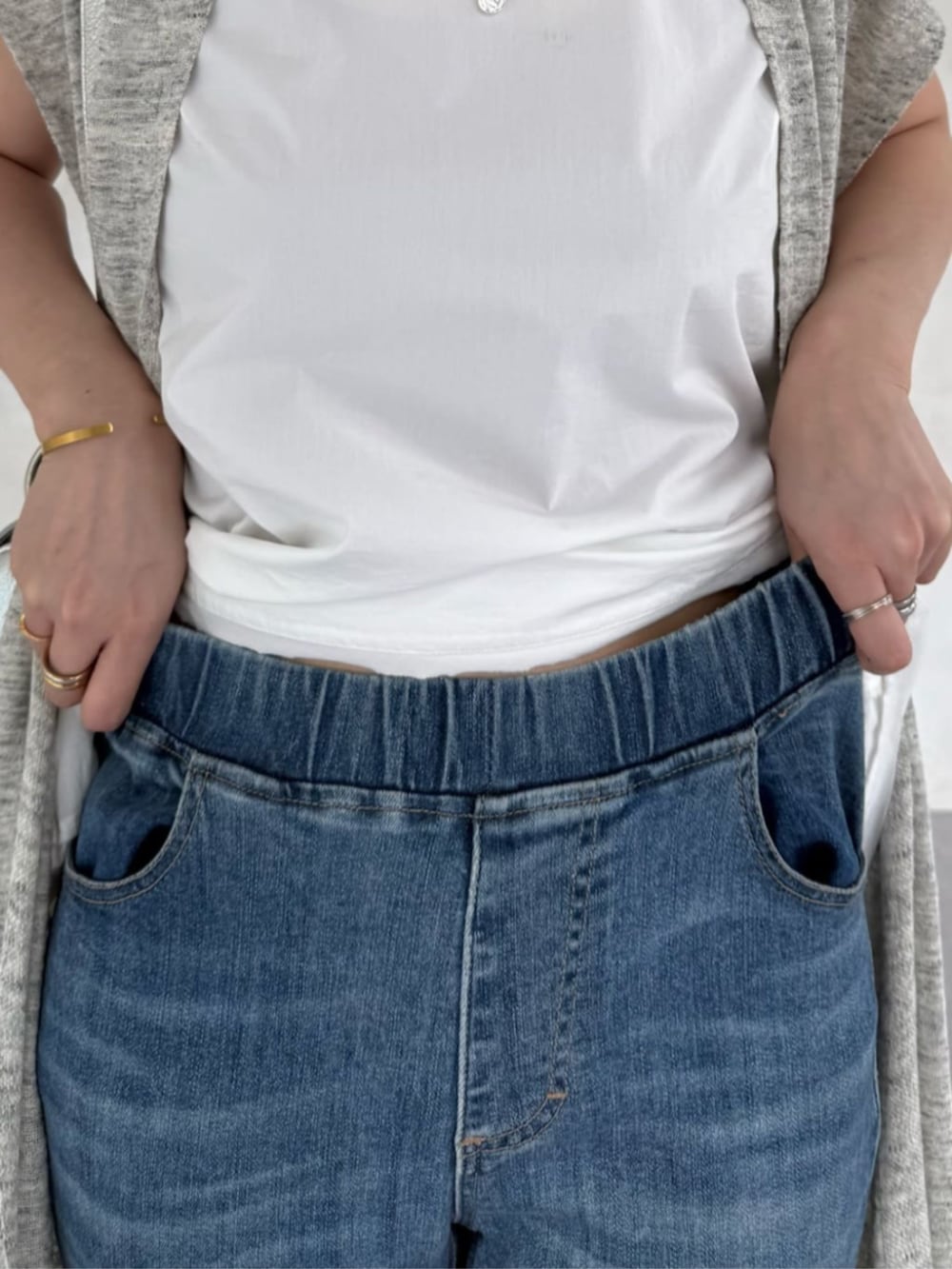 ホワイト系のタンクトップ、ブルー系のデニムパンツ、シルバー系のショルダーバッグを着用したレディースの春コーディネートの8枚目の写真