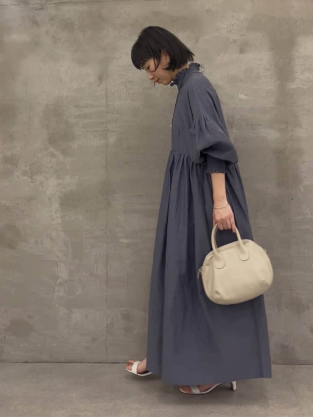 グレー系のボストンバッグ、グレー系のワンピースを着用したレディースの冬コーディネートの4枚目の写真