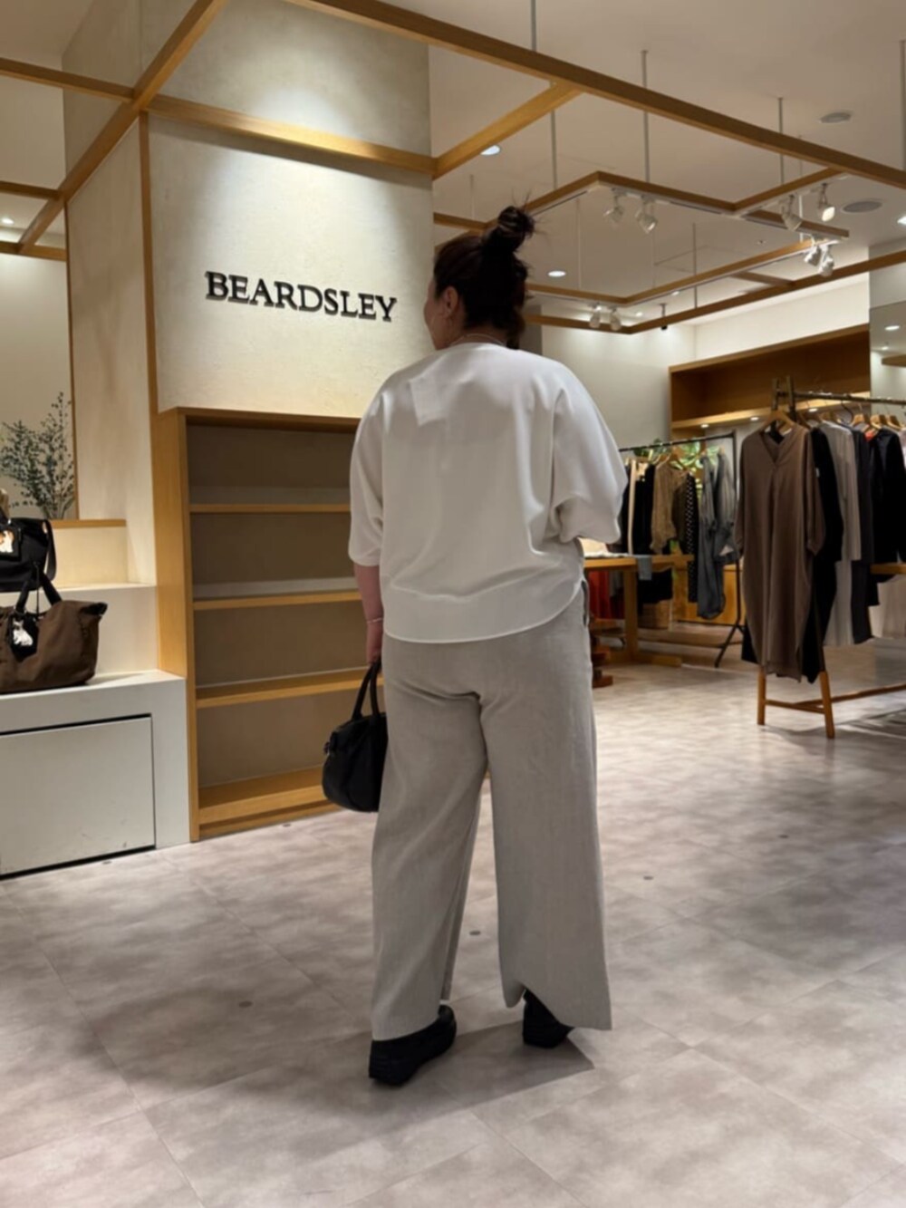 ブラック系のボストンバッグ、ベージュ系のその他パンツ、ホワイト系のTシャツ/カットソーを着用したレディースの春コーディネートの5枚目の写真