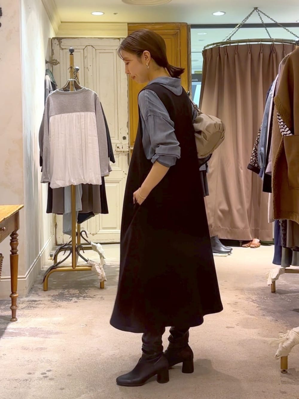 ブルー系のシャツ/ブラウス、ベージュ系のショルダーバッグ、ブラック系のジャンパースカートを着用したレディースの冬コーディネートの3枚目の写真