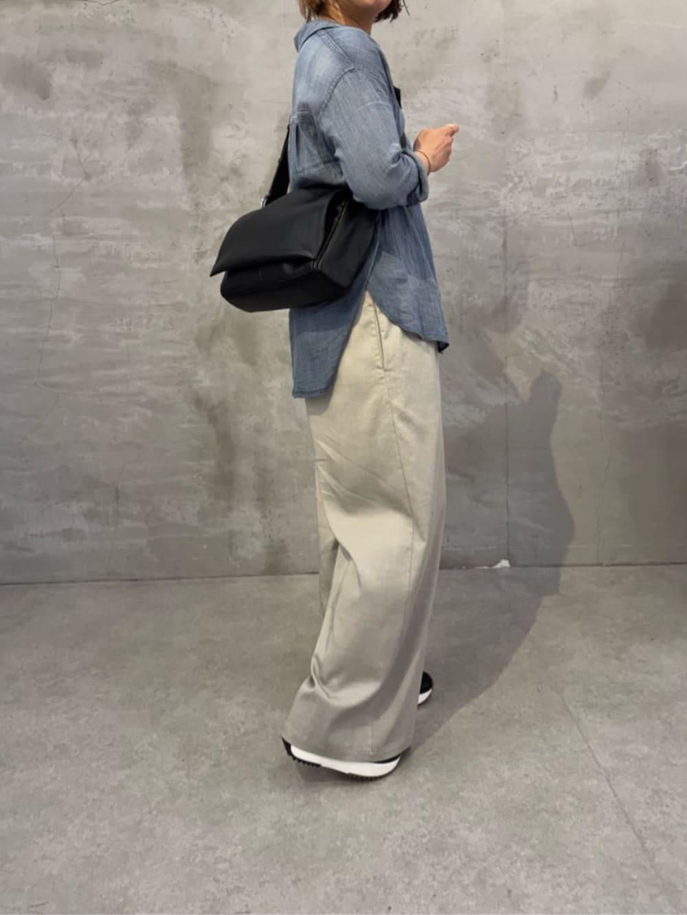 ブルー系のシャツ/ブラウス、ブラック系のショルダーバッグを着用したレディースの春コーディネートの3枚目の写真