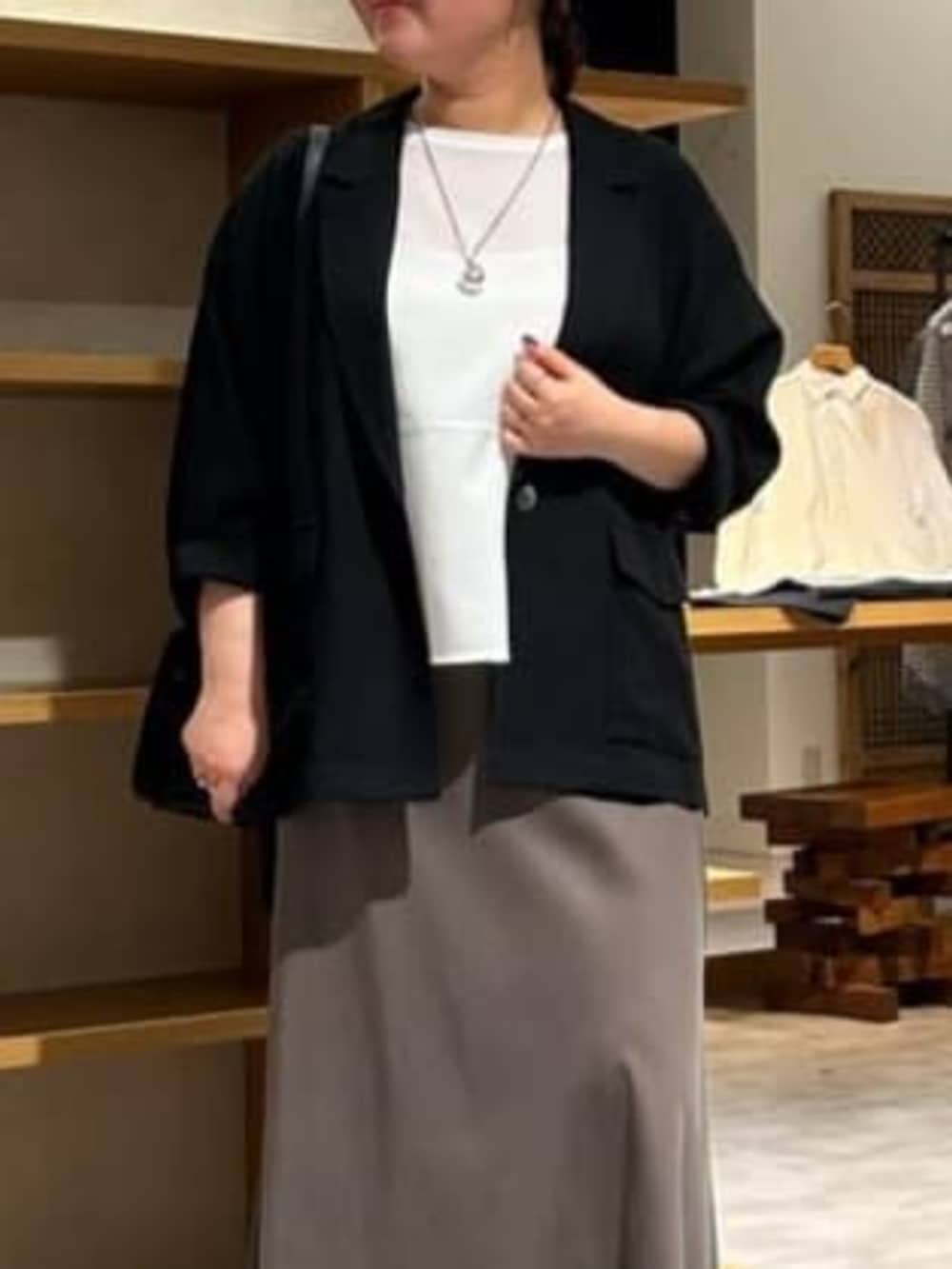 グリーン系のスカート、ブラック系のテーラードジャケット、ホワイト系のシャツ/ブラウスを着用したレディースの春コーディネートの3枚目の写真