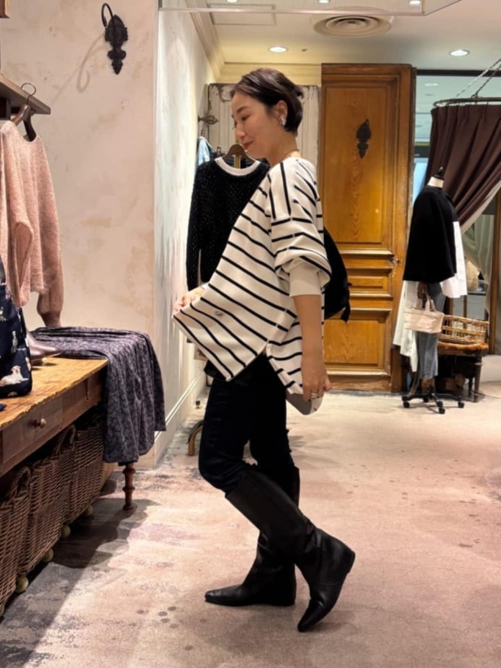 ブルー系のデニムパンツ、ホワイト系のニット/セーター、ブラック系のショルダーバッグを着用したレディースの冬コーディネートの5枚目の写真