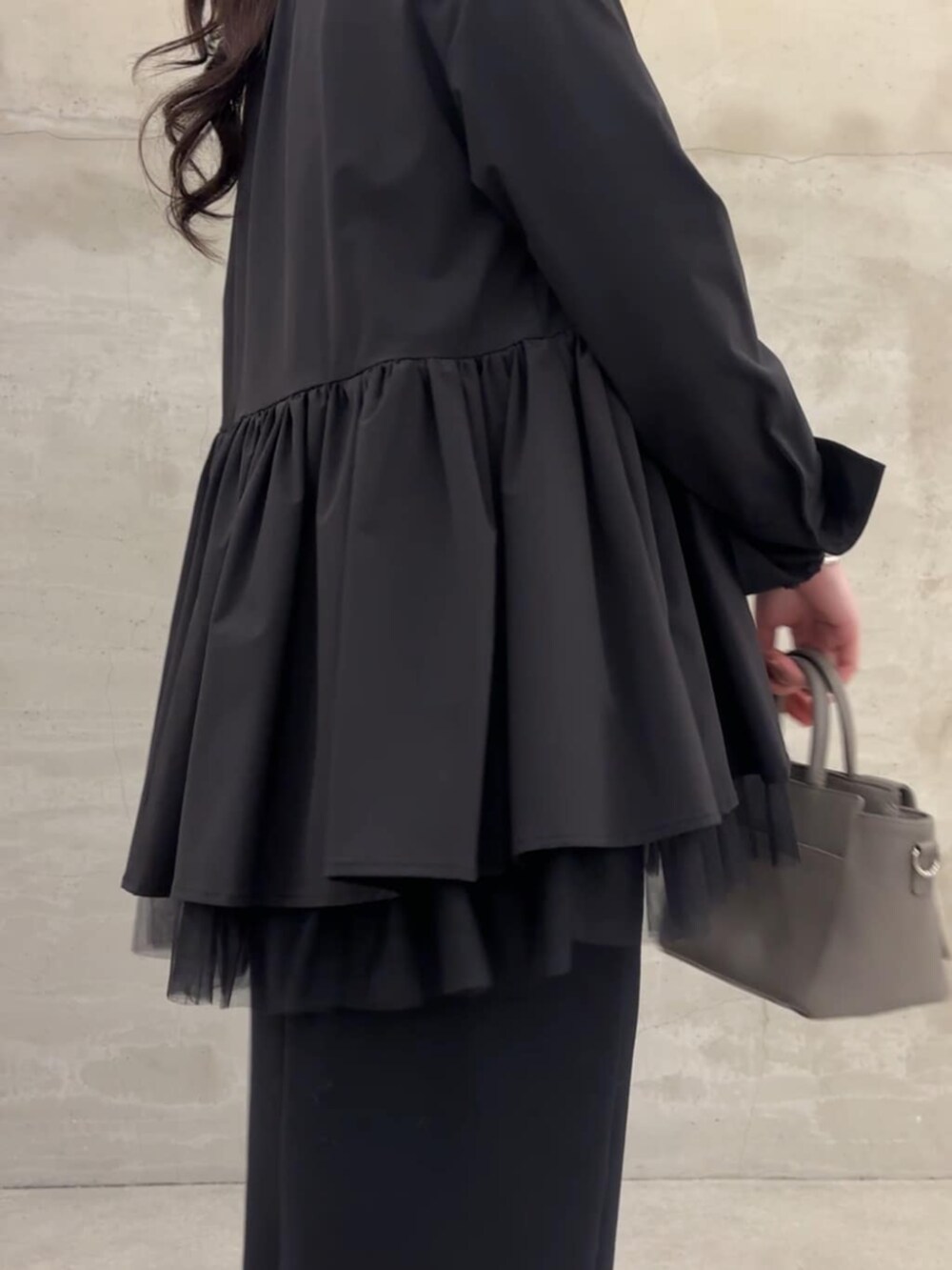 ブラック系のスカート、ブラック系のブルゾンを着用したレディースの冬コーディネートの7枚目の写真