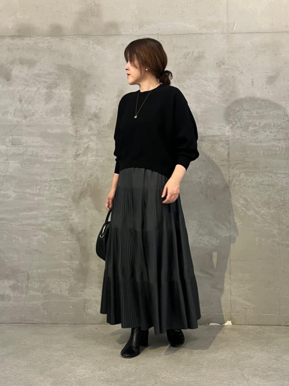 ブラック系のスカート、ブラック系のトートバッグ、ブラック系のニット/セーターを着用したレディースの夏コーディネートの5枚目の写真
