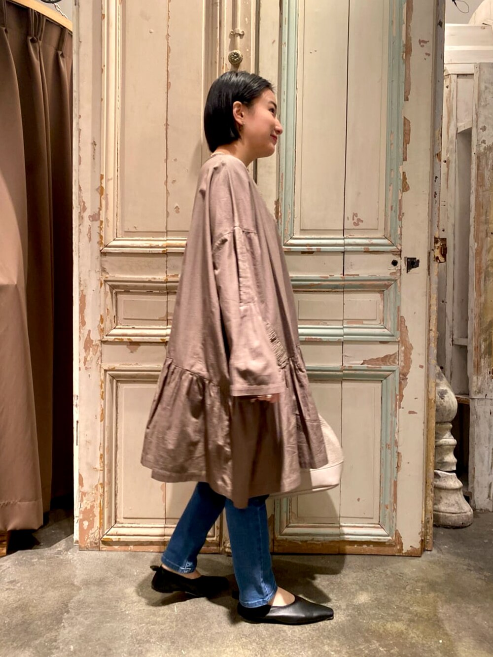 グリーン系のシャツ/ブラウス、ブルー系のデニムパンツ、ベージュ系のトートバッグを着用したレディースの春コーディネートの2枚目の写真