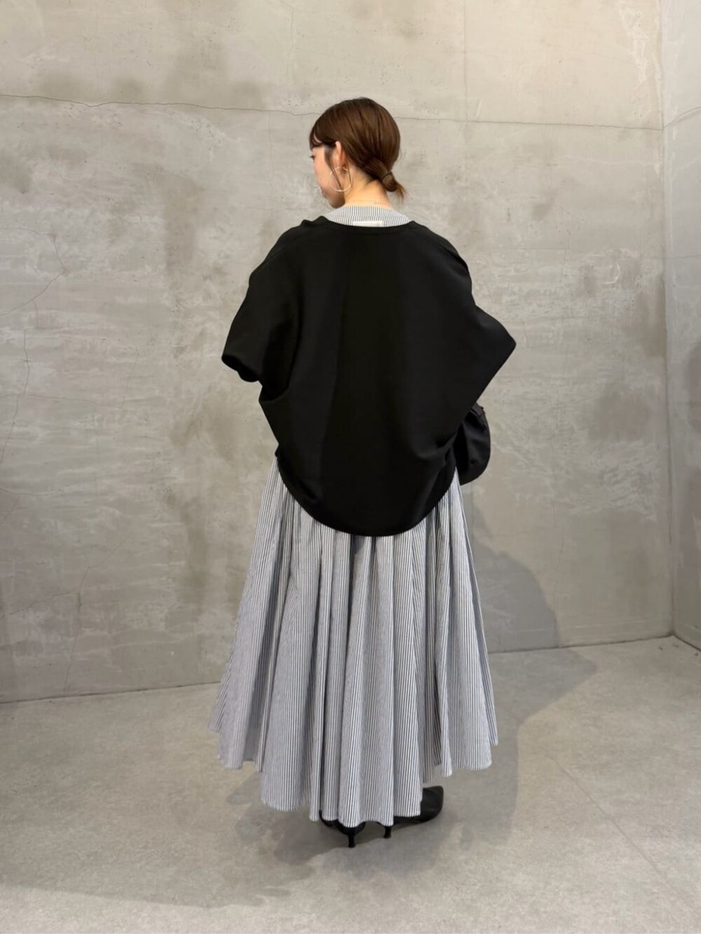 ブラック系のボストンバッグ、ブラック系のカーディガン/ボレロ、ブルー系のワンピースを着用したレディースの冬コーディネートの3枚目の写真